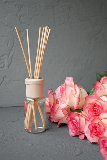 oil diffuser, bamboo sticks, pink roses, aromatic diffuser, textured gray background, fragrance diffuser, essential oil diffuser, reed diffuser, floral arrangement, home decor, aromatherapy