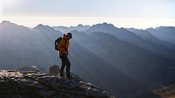 turista, oranžová bunda, skalnatý vrchol, svítání, výhled na hory, osamělý turista, Úchvatný výhled, Mountain Exploration, venkovní dobrodružství, východ slunce výlet, přírodní scenérie