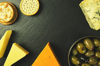 cheese platter, slice cheese, biscuits, bowl of fruits, crackers, olives, slate background, delectable cheese, various cheeses, cheese and crackers, cheese and olives