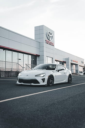 modern white car, Toyota showroom, stylish car, parked car, Toyota dealership, showroom front, white vehicle, modern vehicle, car dealership, stylish modern car, white Toyota car