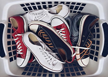 Vintage Turnschuhe, ungepaarte Turnschuhe, Wäschekorb, verschiedene Turnschuhe, Stil und Nostalgie, weiße Turnschuhe, rote Turnschuhe, schwarze Turnschuhe, Freizeitschuhe, Retro -Schuhe, Sneaker-Kollektion