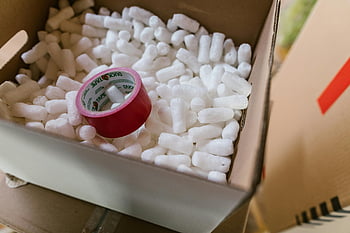 red Scotch tape, cardboard box, packing peanuts, polystyrene, close-up, red tape, packing materials, shipping supplies, protective packaging, box contents, tape roll