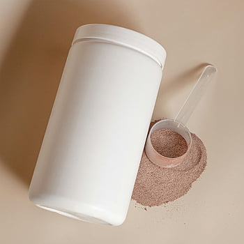 instant cocoa powder, white container, cocoa powder spilling, scoop, powder, container, spilling powder, white container with cocoa, cocoa powder, scoop next to container, spilling cocoa powder