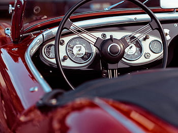 black steering wheel, classic red convertible, vintage speedometer, dashboard view, close-up car interior, retro car details, vintage car dashboard, classic car steering wheel, red convertible interior, vintage car controls, classic car speedometer