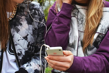 dvě ženy, bílý iphone 4, špunty, sdílení hudby, chytrý telefon, venku, Mladá žena, sluchátka, užívat si čas, multi-tasking, využití technologie