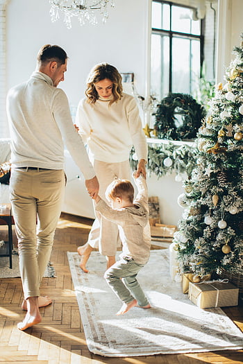 family dancing, Christmas tree, holiday cheer, family bonding, Christmas gifts, festive atmosphere, holiday season, family time, Christmas decorations, joyful family, indoor celebration