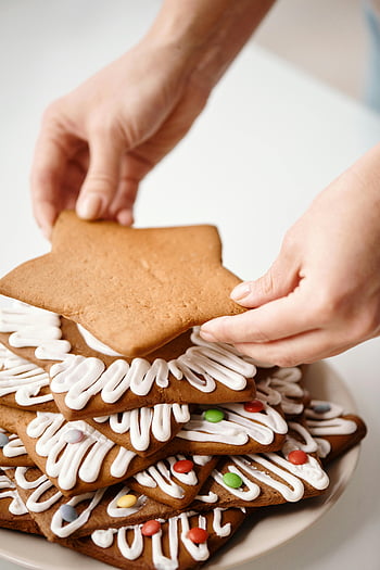Lebkuchen Kekse, Weihnachtsbäckerei, Feiertagsbacken, Keksdekoration, sternförmiger Keks, brauner Keks, weiße Zuckerglasur, Festliche Kekse, Weihnachtsplätzchen, Backthemen, Nahaufnahme