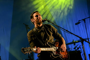 uomo che suona la chitarra, chitarra elettrica rossa e nera, performance sul palco, musica dal vivo, microfono, illuminazione da concerti, musicista, configurazione del palcoscenico, chitarrista elettrico, arte performativa, Spotlight