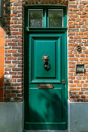 green wooden door, brown brick wall, vintage green door, lion head knocker, vibrant brick facade, classic architectural charm, green door, brick wall, lion knocker, vintage door, architectural charm