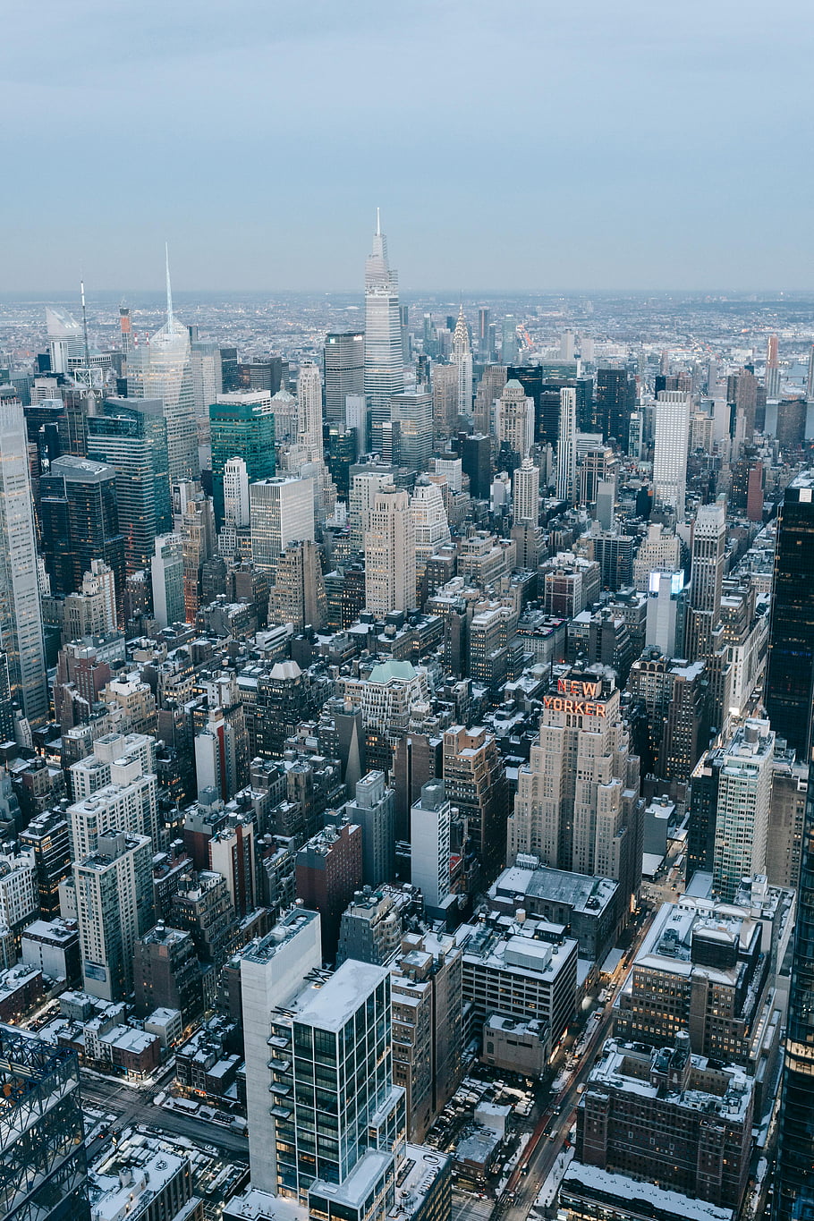 York City, skyscrapers, modern city district, aerial shot, snow-covered, urban winter, clear skyline, cityscape, winter beauty, high-rise buildings, urban landscape