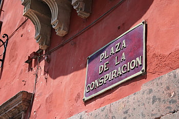 Plaza De La Conspiracion, San Miguel de Allende, Mexico, vibrant red wall, signage, travel destination, historic site, tourist attraction, cultural landmark, street sign, Mexican architecture