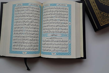 Koran, Arabische Kalligraphie, Religiöse Schriften, Nahaufnahmefoto, Koran offen, graue Oberfläche, Islamischer Text, heiliges Buch, Koran Seiten, detaillierte Ansicht, Spirituelle Literatur