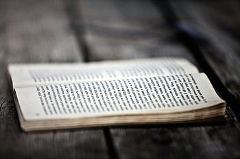 åbnet bog, træbræt, tæt på, tekst i fokus, forvitret træoverflade, bog på træ, læsning, litteratur, vintage bog, rustik baggrund, åbne sider