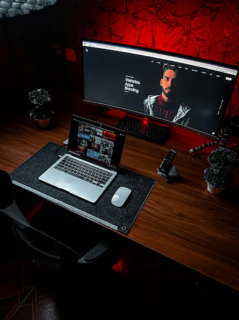 laptop, computer monitor, wooden table, red ambient lighting, stylish workspace, sleek modern aesthetic, desk setup, office environment, tech workspace, computer desk, ambient light