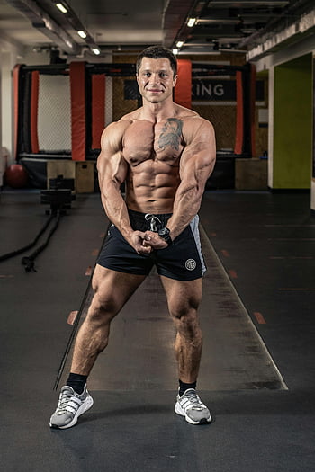 mand, sort shorts, bøjning af musklerne, fit mand, indendørs gymnastiksal, viser muskler, Gymnastiksalsmiljø, Muskelfysik, atletisk krop, fitness model, træningsudstyr