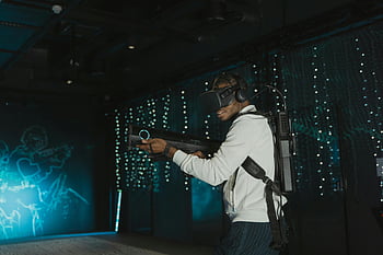ชุดหูฟัง vr, เกมเสมือนจริง, ผู้ชายผู้ใหญ่, อาวุธจำลอง, ประสบการณ์การเล่นเกม, เทคโนโลยีที่ดื่มด่ำ, ความบันเทิงแบบโต้ตอบ, สภาพแวดล้อมเสมือนจริง, เทคโนโลยีการเล่นเกม, ประสบการณ์เสมือนจริง, เกม vr
