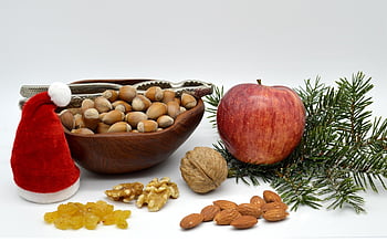 Nocciole, noce, uva passa, motivo natalizio, Mela, noccioline, schiaccianoci, mandorle, ciotola di legno, cappello da Babbo Natale, ramo di abete