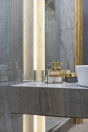 modern bathroom, stylish bathroom counter, elegant toiletries, marble countertop, mirror reflections, gold accents, bathroom decor, luxury bathroom, contemporary bathroom, bathroom vanity, toiletry set