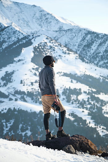 man, gray long-sleeved shirt, brown shorts, black DSLR camera, mountain, snowy terrain, Ak-Talaa District, Kyrgyzstan, winter landscape, adventurer, exploration