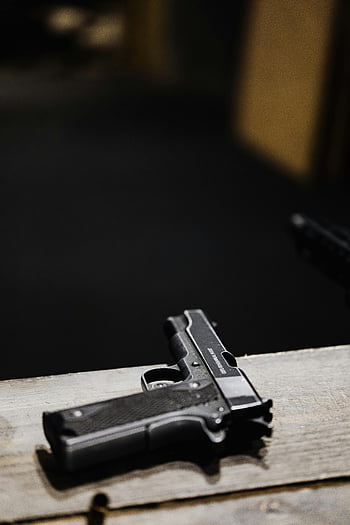 pistol, close-up, detailed shot, wooden surface, indoor setting, handgun, firearm, gun, black pistol, indoor photography, close-up photography