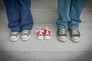 blue denim pants, gray white low tops, baby sneakers, family footwear, growth representation, casual shoes, adult shoes, red baby shoes, family growth, footwear comparison, denim pants sneakers