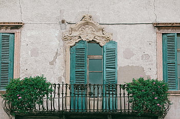 old residential building, balcony, European building, weathered shutters, ornate balcony, vintage charm, old facade, green shutters, floral balcony, architectural details, European architecture
