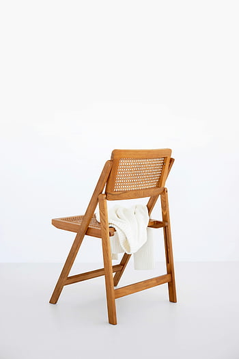 brown wooden folding chair, white floor, cozy white sweater, minimalist background, wooden chair, white sweater, folding chair, white background, cozy chair, minimalist decor, white sweater draped