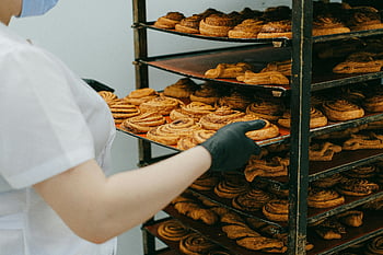 cinnamon rolls, bakery kitchen, freshly baked, cooling rack, baker, tray, pastry, baked goods, food photography, baking process, gloves