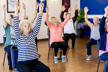 Cvičení seniorů, Třída cvičení židle, starší dospělí, zdatnost, zdravý životní styl, skupinové cvičení, Vnitřní cvičení, aktivní senioři, Starší fitness, komunitní aktivita, Wellness program