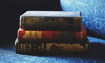 antikke bøker, dekorative bindinger, blå stoffsofa, bunke med bøker, vintage bøker, utsmykkede omslag, gamle bøker, boksamling, antikk litteratur, bokstabel, blå sofa