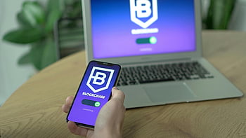 blockchain app, black Android smartphone, hand holding phone, laptop background, desk setup, cryptocurrency, digital wallet, blockchain technology, mobile app, tech workspace, blockchain interface