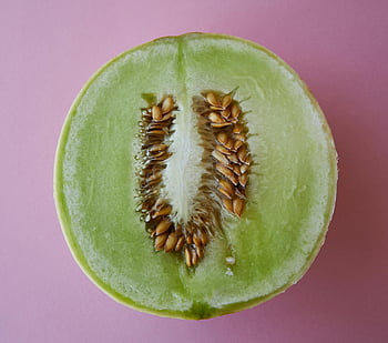 juicy melon, half cut melon, seeds, ripe honeydew melon, sliced melon, vibrant pink background, top view, melon seeds, green melon, fruit, healthy food