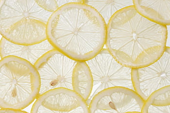 lemon slices, close-up shot, white surface, vibrant texture, fresh lemons, citrus fruit, lemon texture, lemon freshness, lemon arrangement, white background, citrus slices