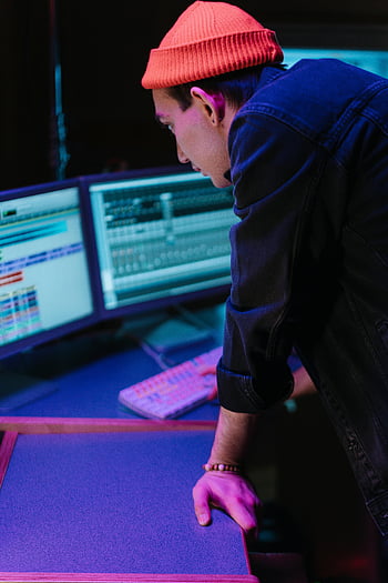 若者、 オレンジビーニー、 コンピューターデスク、 複数のモニター、 ワーキング、 コンピュータ画面、 机のセットアップ、 技術、 ワークスペース、 集中した、 生産性