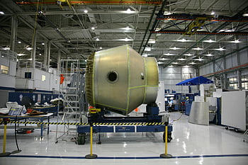 rocket factory, spaceship assembly, aerospace factory, large machinery component, modern factory, spacecraft manufacturing, industrial machinery, factory interior, aerospace manufacturing, spacecraft production, factory equipment