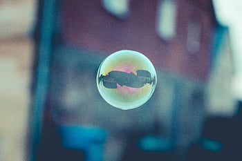 soap bubble, urban scenery, bubble photography, blurred background, reflection, single bubble, colorful, dreamlike, transparent, floating object, artistic