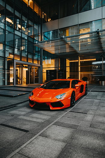 orange sports car, Lamborghini Aventador, modern architecture, parked car, dynamic shot, urban setting, luxury vehicle, orange car, modern building, cityscape, high-end sports car