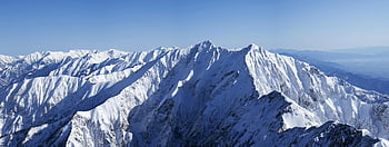 snowy mountain peaks, clear blue sky, winter landscape, snow-covered mountains, mountain scenery, alpine view, natural beauty, high altitude, snow-capped peaks, mountain range, winter wonderland