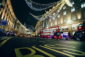 London night scene, illuminated buildings, festive lights, red double-decker bus, vibrant night, city at night, Regent Street, Christmas lights, urban nightlife, night photography, festive atmosphere