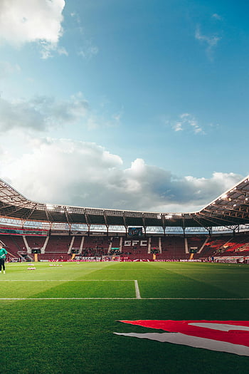 campo de futebol, Estádio de Genebra, Grama verde vibrante, céu azul claro, nuvens brancas, vista panorâmica, estádio de esporte, Estádio ao ar livre, campo de esportes, Arquitetura do estádio, dia ensolarado