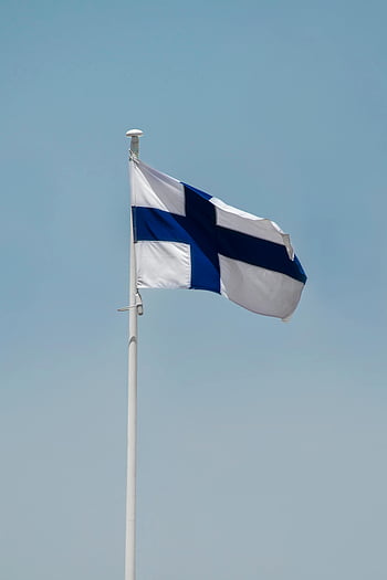 Finnish flag, flagpole, clear blue sky, Helsinki, Finland, waving flag, national flag, blue and white, outdoor scene, Finnish symbol, Finnish culture
