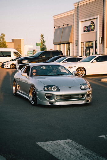 silver Toyota Supra, parking lot, sunny urban setting, luxury car, style car, outdoor parking, Toyota Supra, silver car, urban parking, car enthusiasts, sunny day