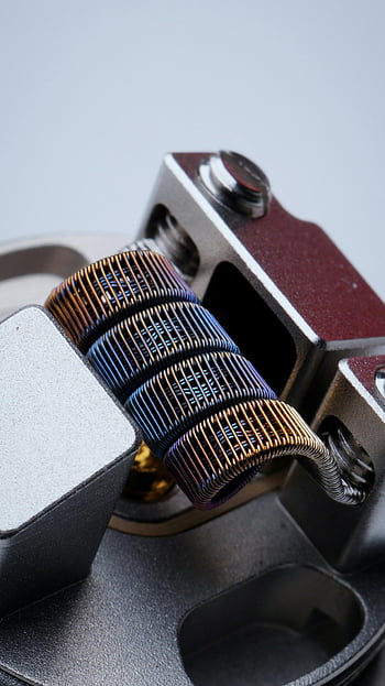 kumparan vape, pemanas logam, Vape modern, kumparan berwarna -warni, detail logam, tampilan close-up, desain yang rumit, peralatan vaping, Teknologi Vape, komponen vape, perangkat keras vape