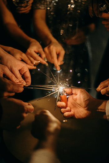 Leute, die Wunderkerzen anzünden, Festliche Feier, Gruppenfeier, Wunderkerzen zusammen, Festliche Atmosphäre, Wunderkerzenbeleuchtung, Gruppenaktivität, Feier Wunderkerzen, Wunderkerze, Nachtfeier