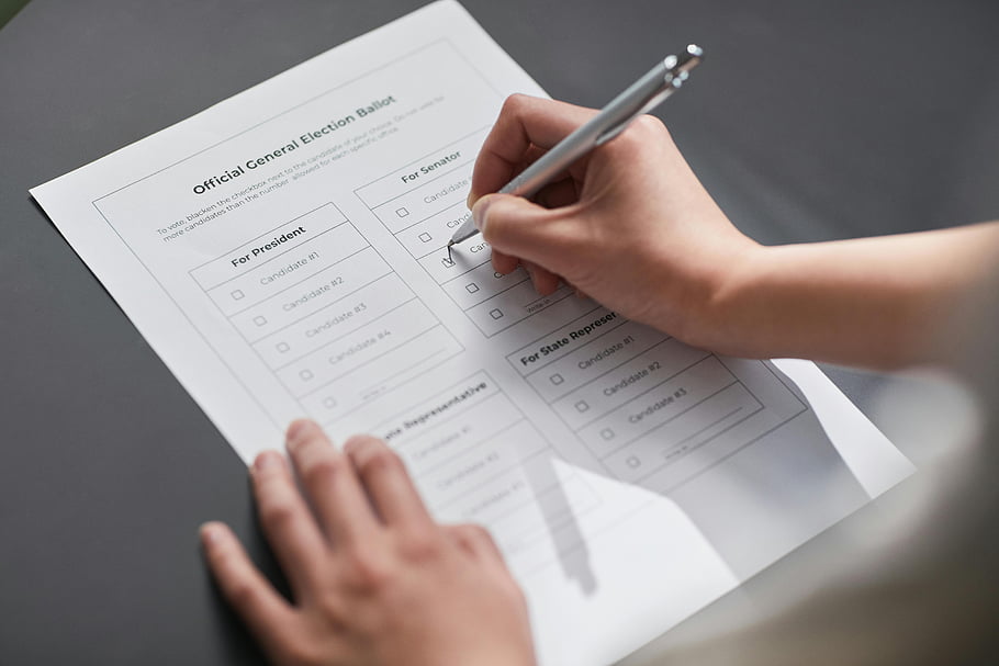 cédula de votação, preenchimento de cédula, votação democrática, cédula eleitoral, marcação manual da cédula, eleição oficial, imagem em close, processo de votação, cédula de marcação com caneta, participação do eleitor, dia de eleição
