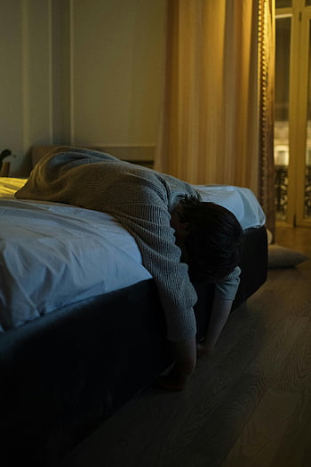 maniche lunghe grigie, sdraiato sul letto, persona stanca, esaurimento, insonnia, notte, Camera da letto, fogli bianchi, stanza buia, le tende, pavimento di legno