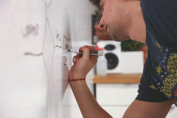 man drawing, dry erase board, whiteboard, marker, office setting, close-up, writing, professional, brainstorming, presentation, education