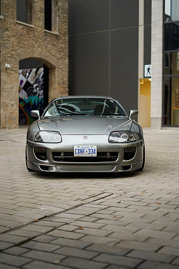 Toyota Supra IV, zaparkováno, budova, město, čelní pohled, Současné městské prostředí, Ontarijská poznávací značka, stříbrné auto, cihlová dlažba, moderní architektura, graffiti zeď