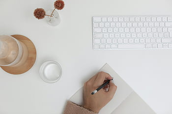 flach liegen, minimalistischer Arbeitsbereich, Tastatur, Hand schreiben, Skizzen auf Papier, weißer Schreibtisch, Arbeitsbereich einrichten, kreativer Schreibtisch, Schreibtischorganisation, Minimalistischer Schreibtisch, Flachlage Fotografie