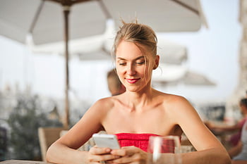 woman, sitting, chair, holding, smartphone, smiling, leisure time, outdoor cafe, umbrella, table, glass